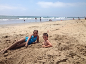 Amy's daughter Shannon and Michael burying each other in the sand.